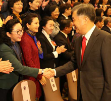 2017年，中共中央政治局常委、全国政协主席汪洋与秦和校长亲切握手